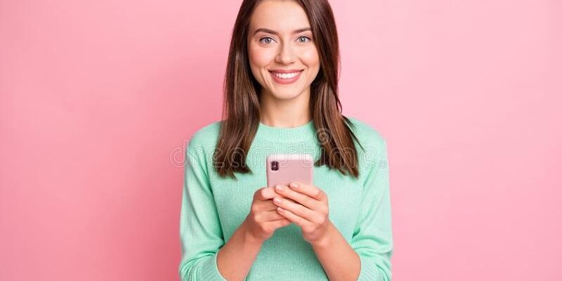 portrait-attractive-young-people-hands-hold-phone-satisfied-teal-sweater-isolated-pink-color-background-204807457